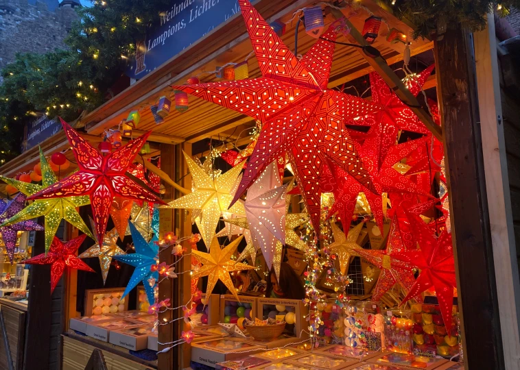 a lighted shop has colorful star decorations outside