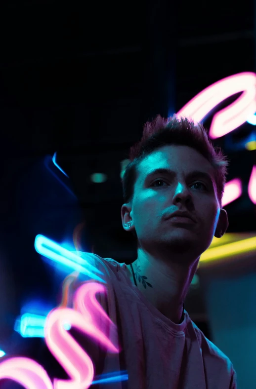 a person standing near neon lights and wearing earphones