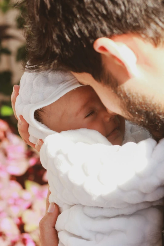 a close up of a person holding a baby in a blanket