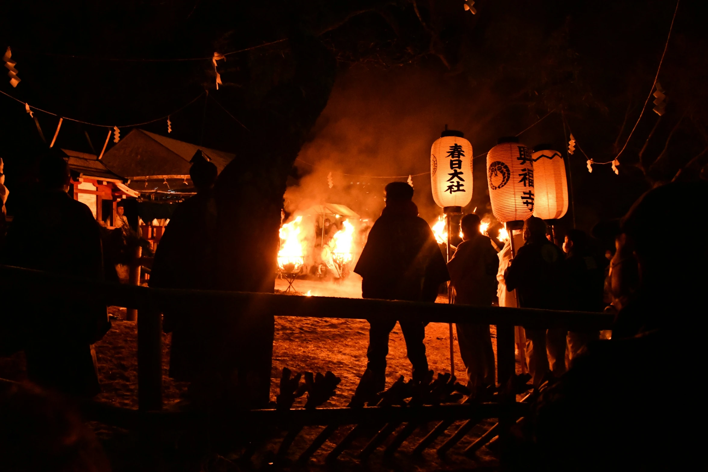 people stand around a bonfire during the festival