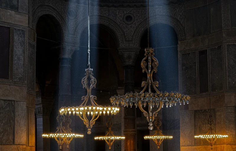 three lights are glowing from the ceiling in a large building