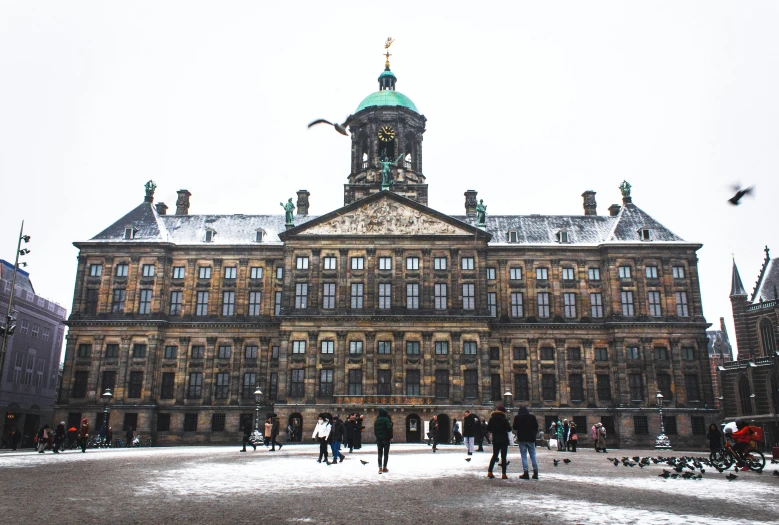 a group of people walking in front of an old building