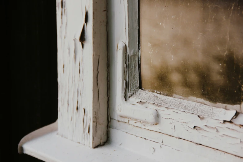 a wooden window frame with peeling paint and peeling windows