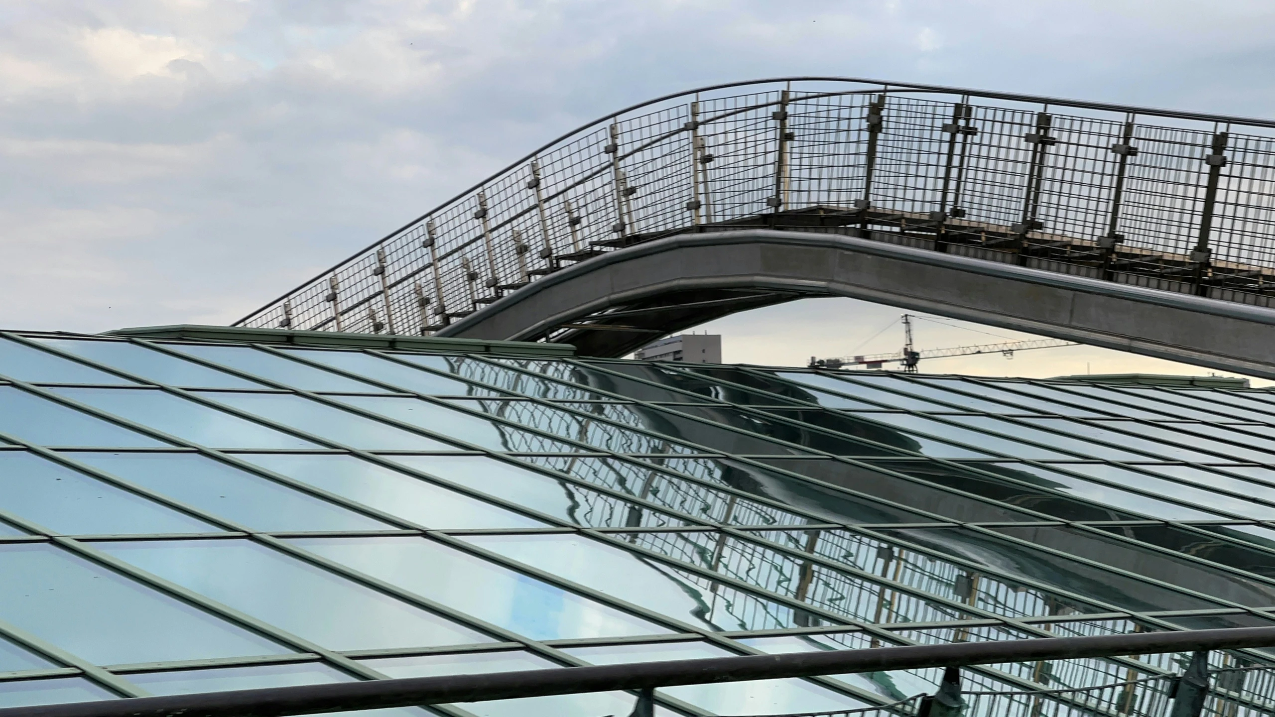 a curved metal walkway that connects to a skyscr