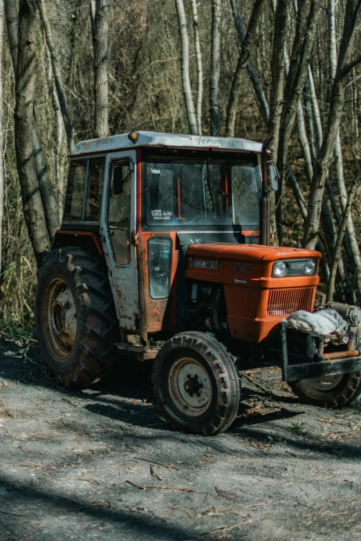 an old tractor sitting on a gravel road