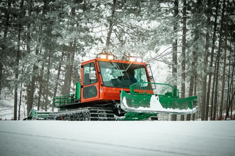 a snow blower is parked near some trees