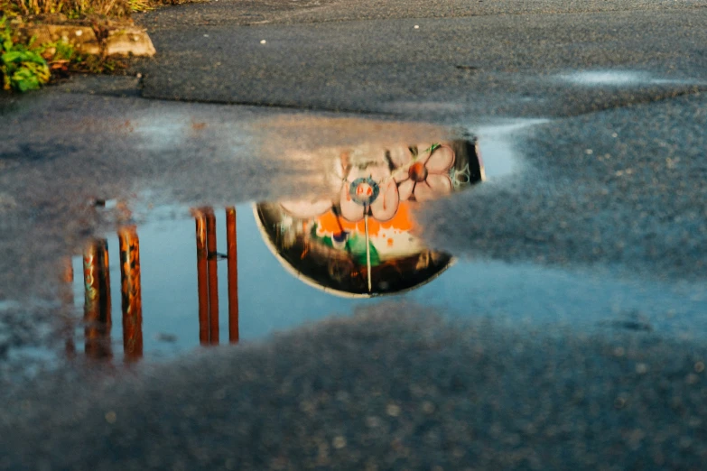 some graffiti on a railing and water in the street