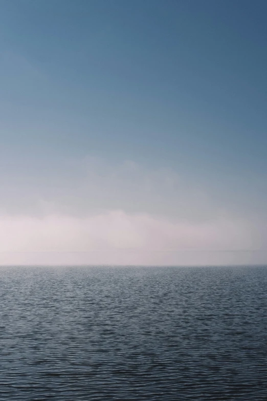 a single wind surfer is alone on the ocean