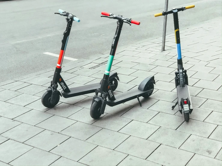 two motorized scooters are on the side of a road