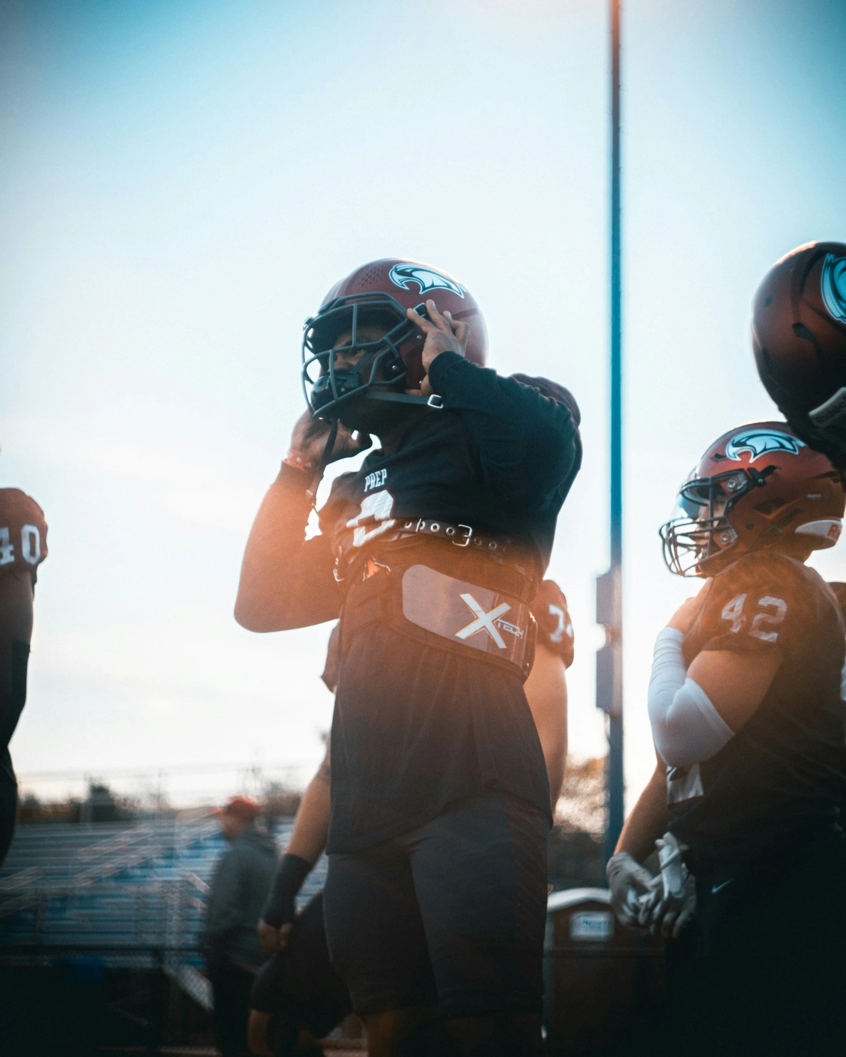 a football player holding his helmet on and facing a pographer in front of him