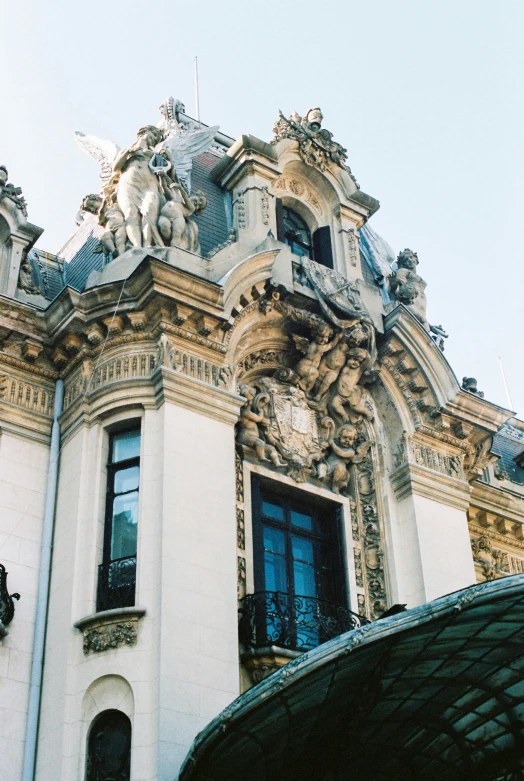 an ornate building has statues atop the windows