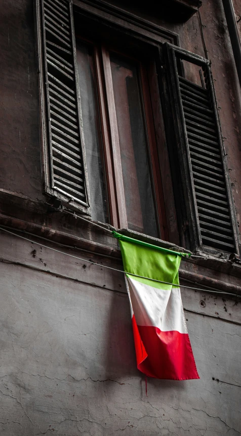 an italian flag hanging on a window