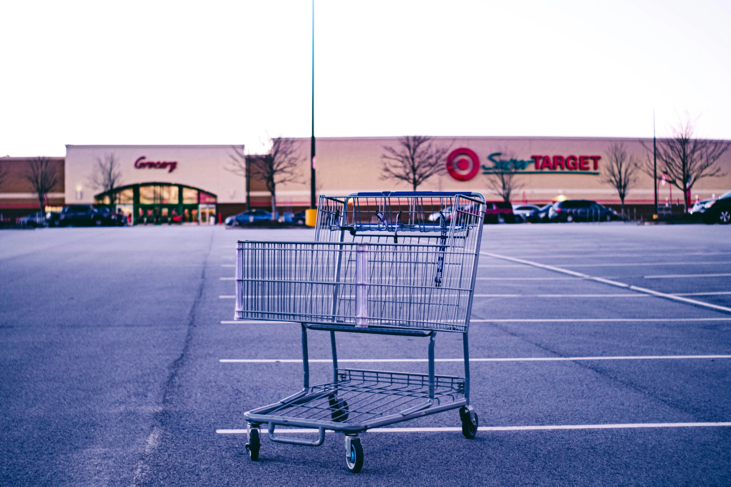 a shopping cart sits empty in a parking lot