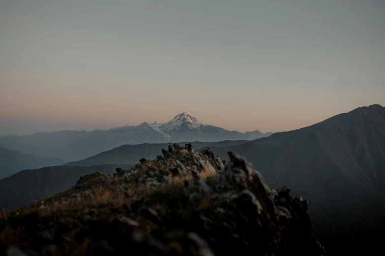 the view from a peak overlooking a snowy mountain range