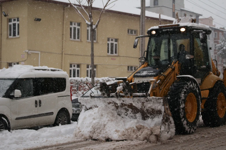 a bulldozer is shoveling the snow from the road