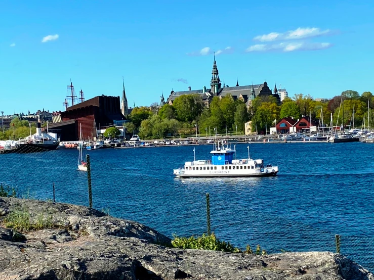 boat in the water with trees and buildings in the background