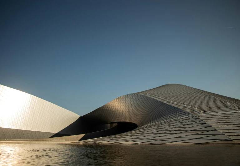 the exterior of a large building with water in the foreground