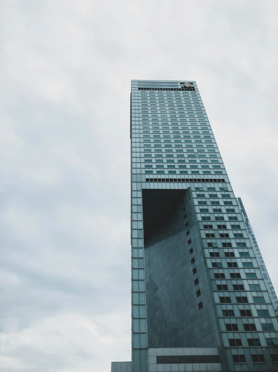 a tall skyscr is in the foreground, against a cloudy sky