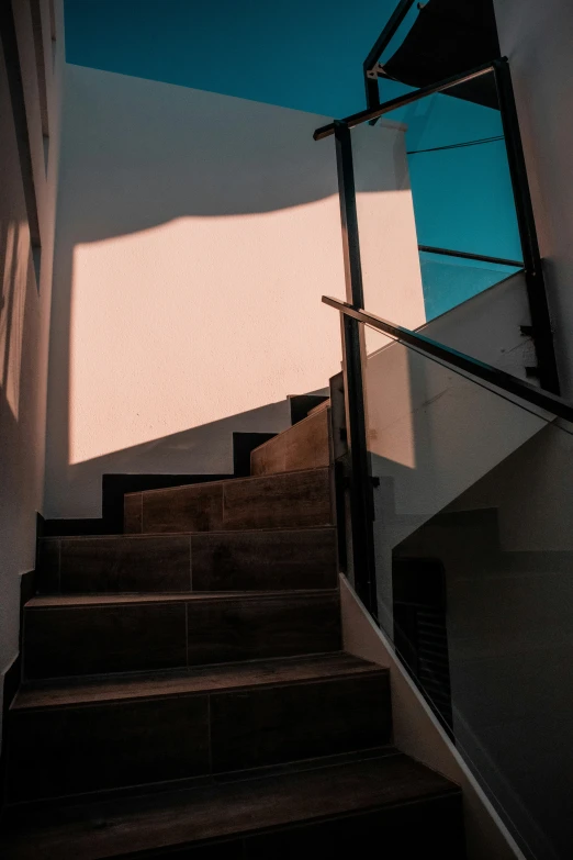 the view from up a stairwell shows light streaming down