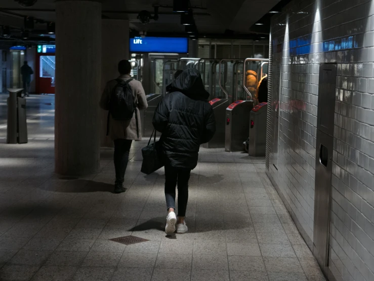 a woman is walking down a public hallway