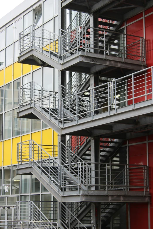 a grey and red stairway leads to two story buildings