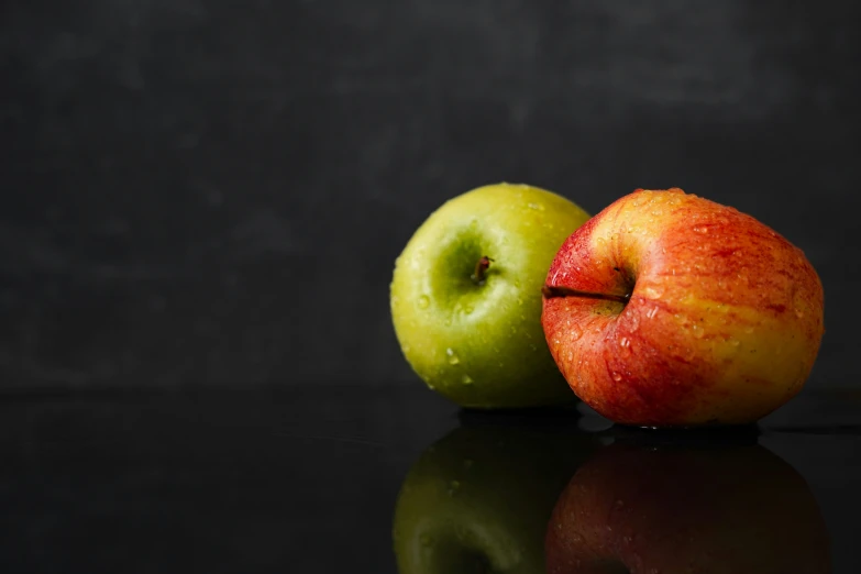 a couple of apples sit next to each other