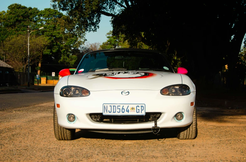 a white sports car with a red racing stripe on its hood