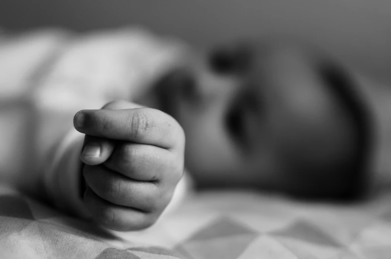 baby pointing his finger at the camera in black and white