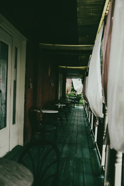 an indoor porch area with tables and chairs