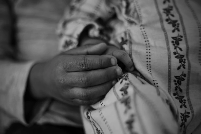 a woman holding the wrist of her baby