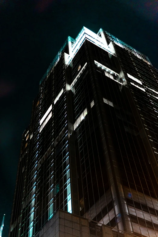 tall, sleek office building in front of a dark sky