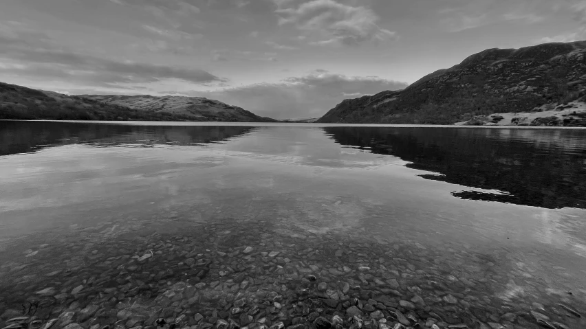 an empty lake in front of some mountains