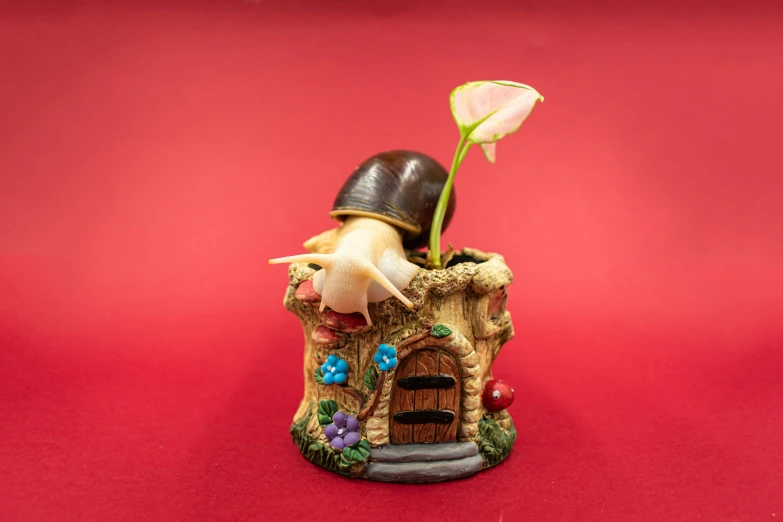 a small doll house with a cat and a flower