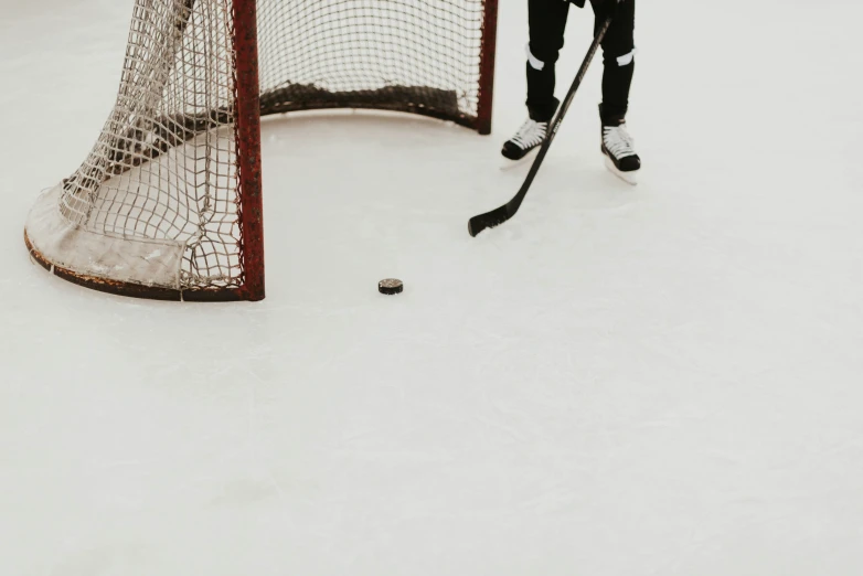 a person on ice playing hockey with puck