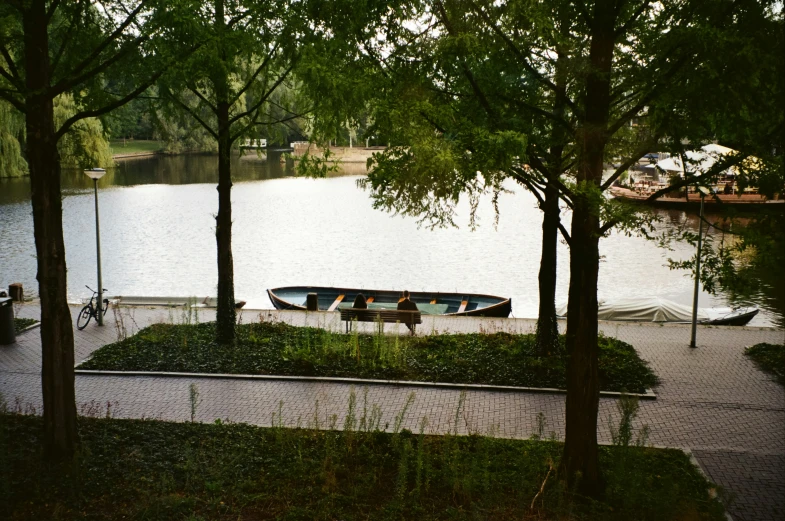 the boat is docked at the bank of a lake