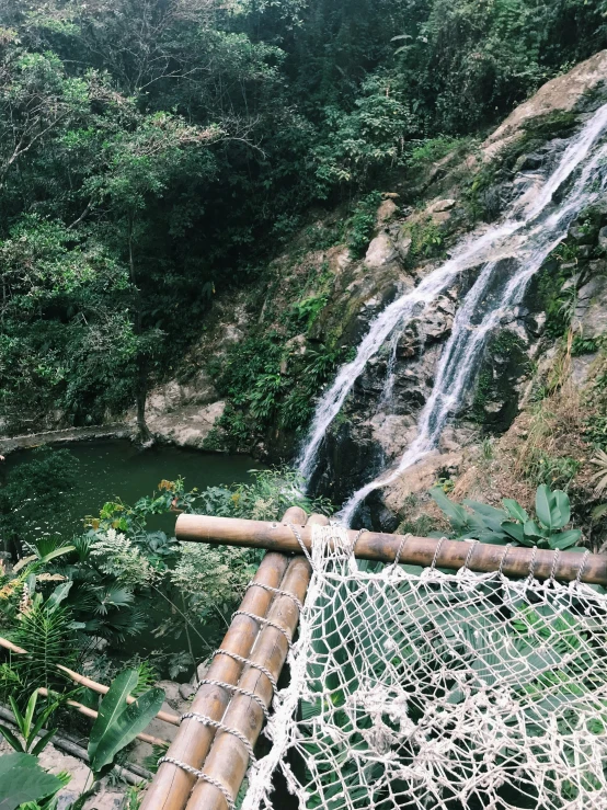 a view of a waterfall next to a green forest