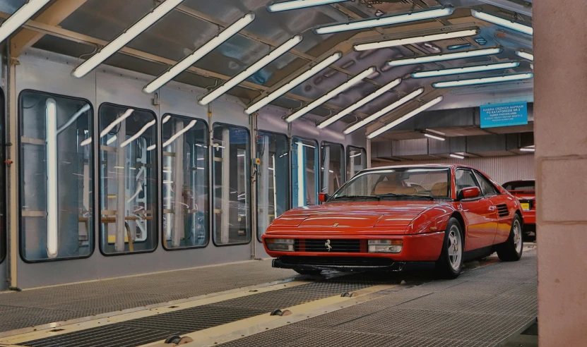 a red car on the train platform waiting