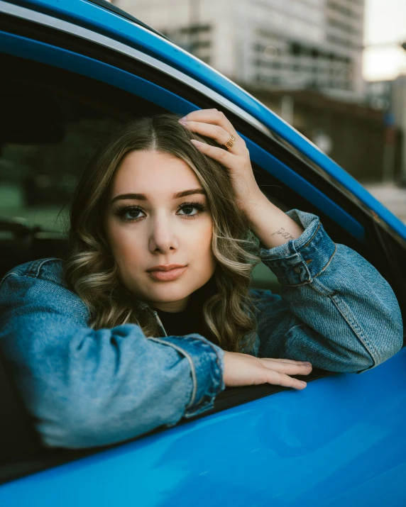 young woman with blue eyes sitting in her car
