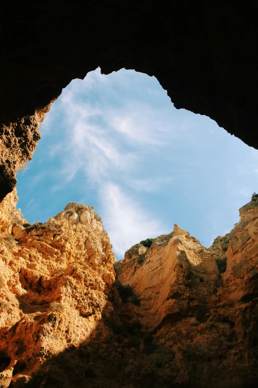 a blue sky that is over a big cave