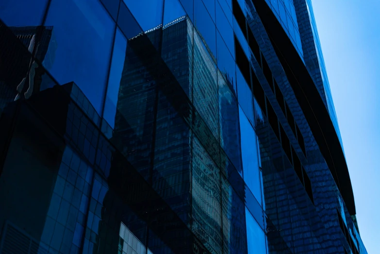 a tall building has a reflection of another large one in it