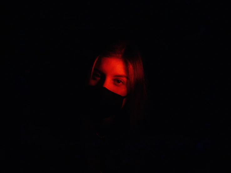 a woman in the dark with a red face