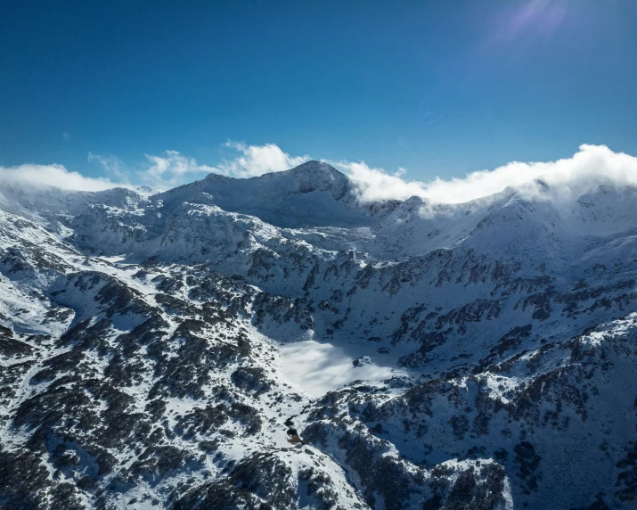 the mountain is covered in snow and clouds