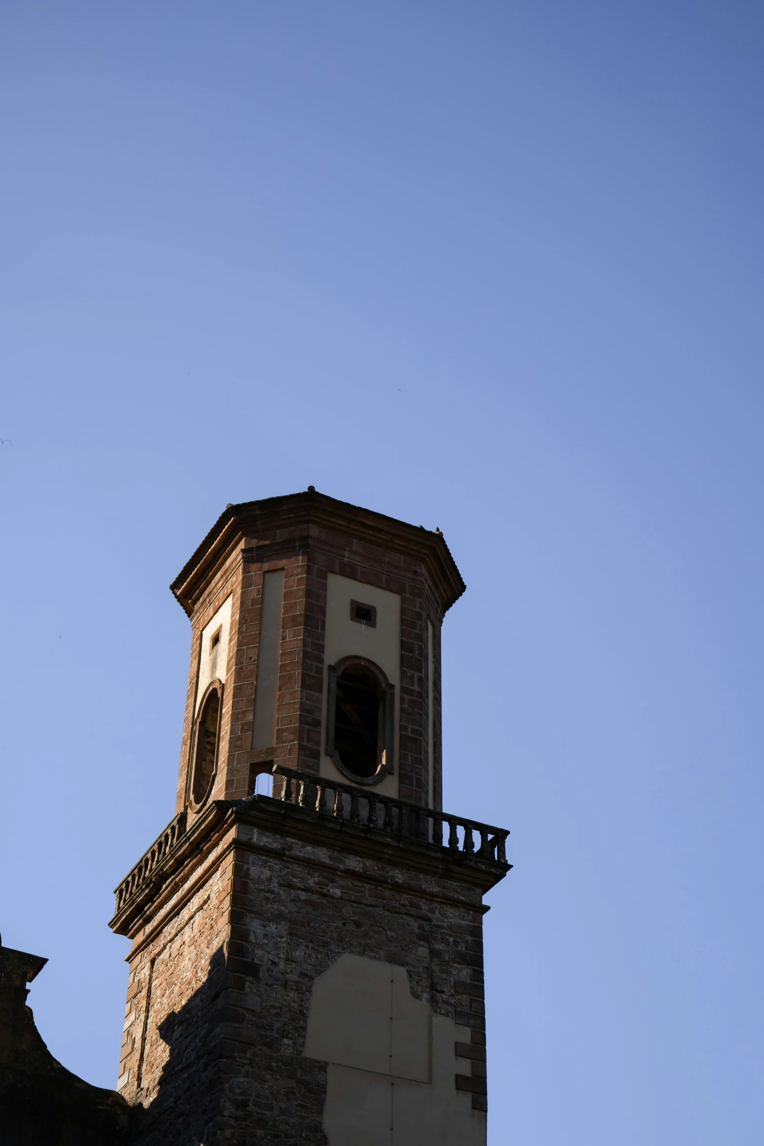 a brick clock tower with a black and white flag