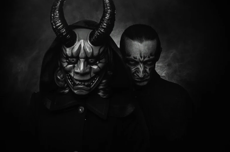 two demonicly dressed people pose for a picture