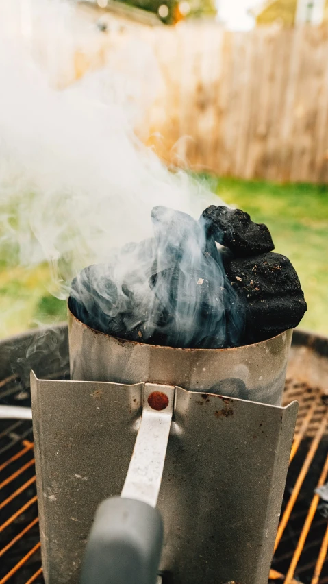 a grill with smoke coming out of it next to an outdoor bbq