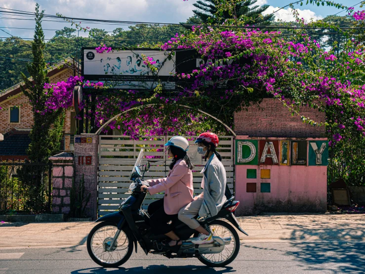 two people riding bicycles in the middle of the road