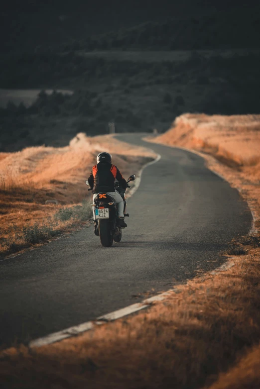 the motorcycle rider is going down the road