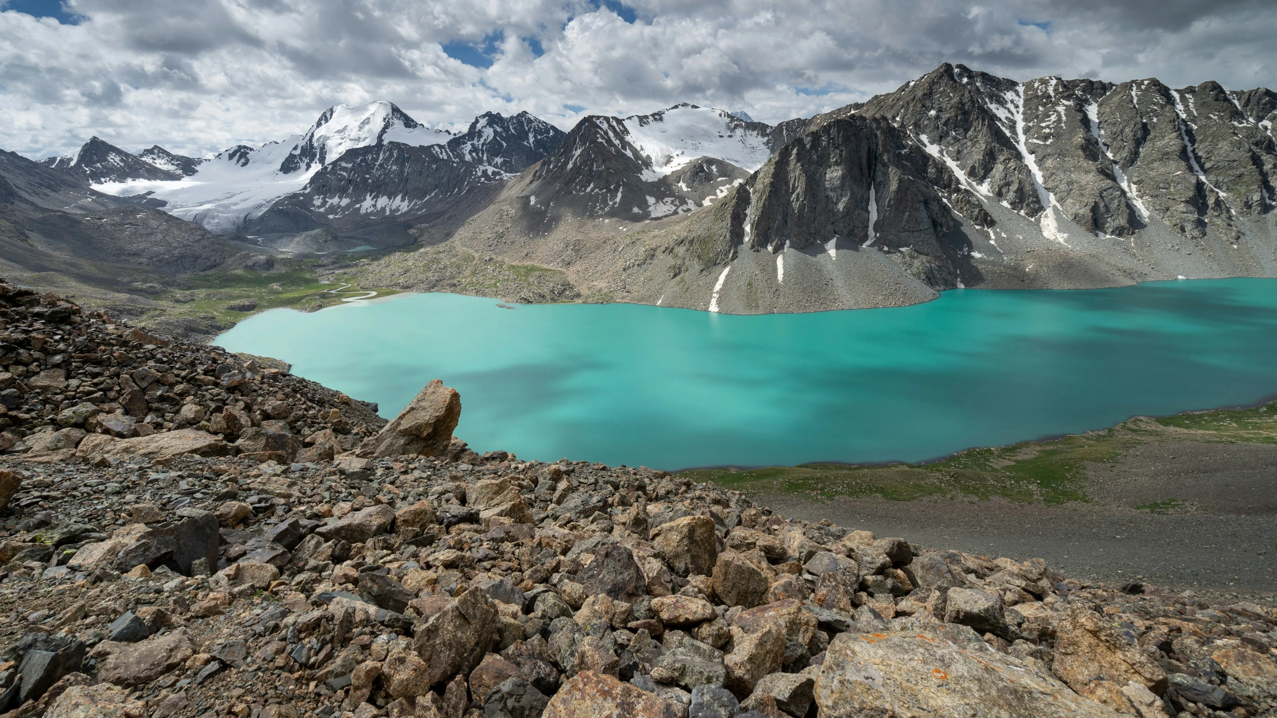 a large blue lake sitting on the side of a mountain