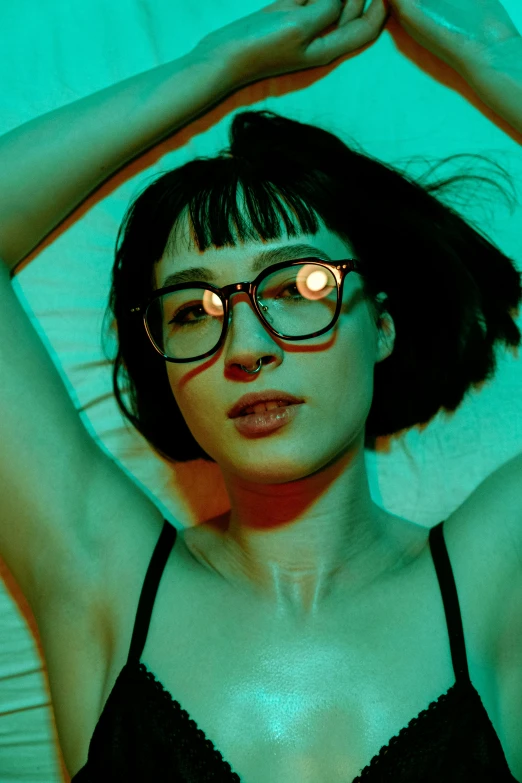 a beautiful woman wearing eye glasses while standing in a dark room