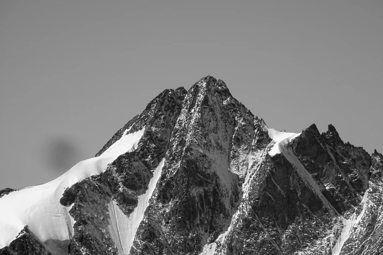 a mountain has snow on the sides and there is no snow on top